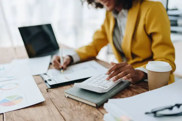 Professional business woman working with calculator and laptop